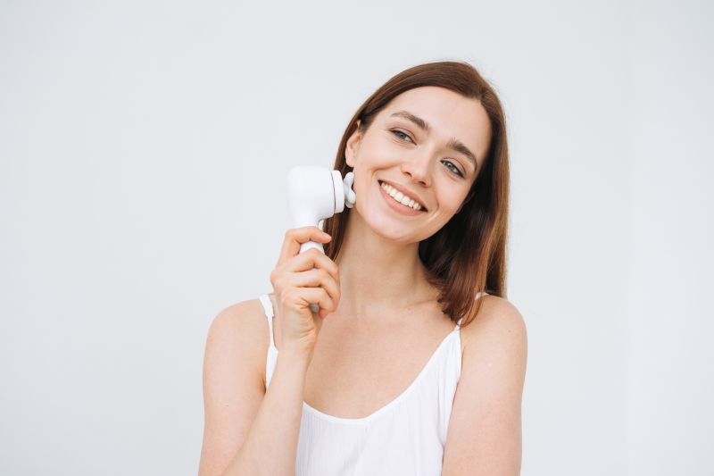 smiling woman with facial massager 