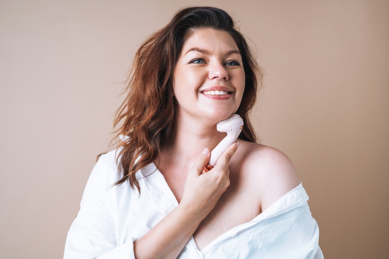 woman with facial massager in hand